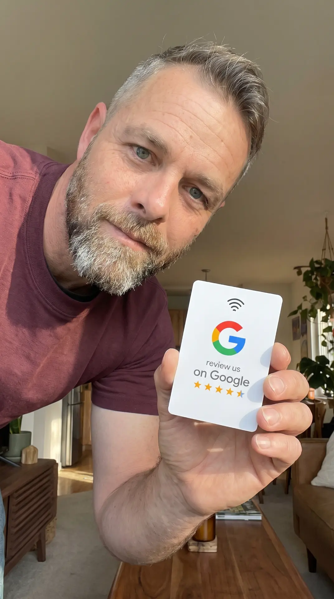 Customer holding a white NFC Google review card at home